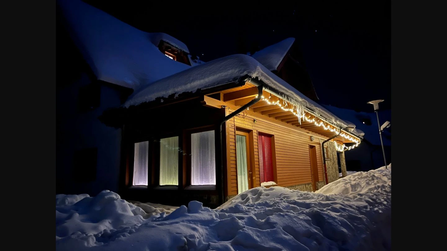 AS Apartments exterior at night with snow and warm lighting